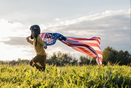 child running with the American flag