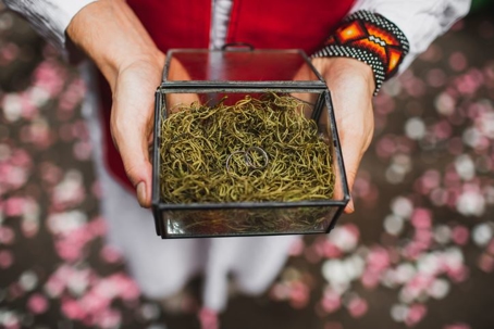 Native American person holding a box with wedding bands