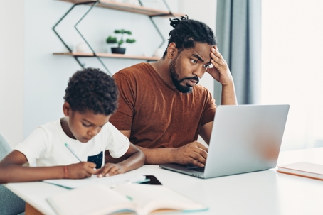 worried parent sitting with child doing homework