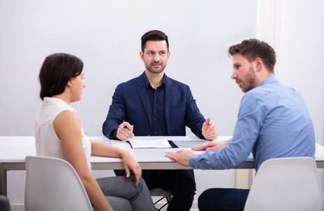 Rear View Of A Couple Sitting In Front Of Another Man
