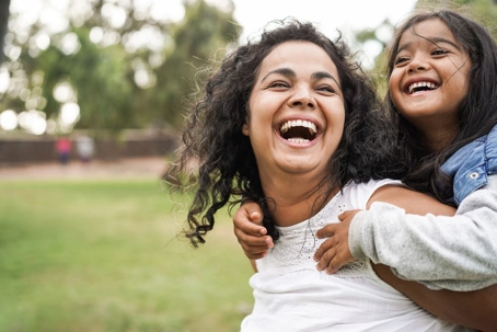 Mom and daughter outside smiling.